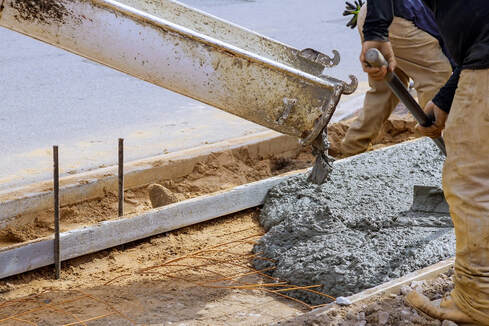 Wet cement being poured and spread by concrete contractors.