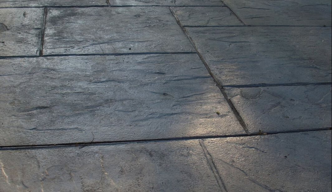 Gray stamped concrete with natural stone texture.